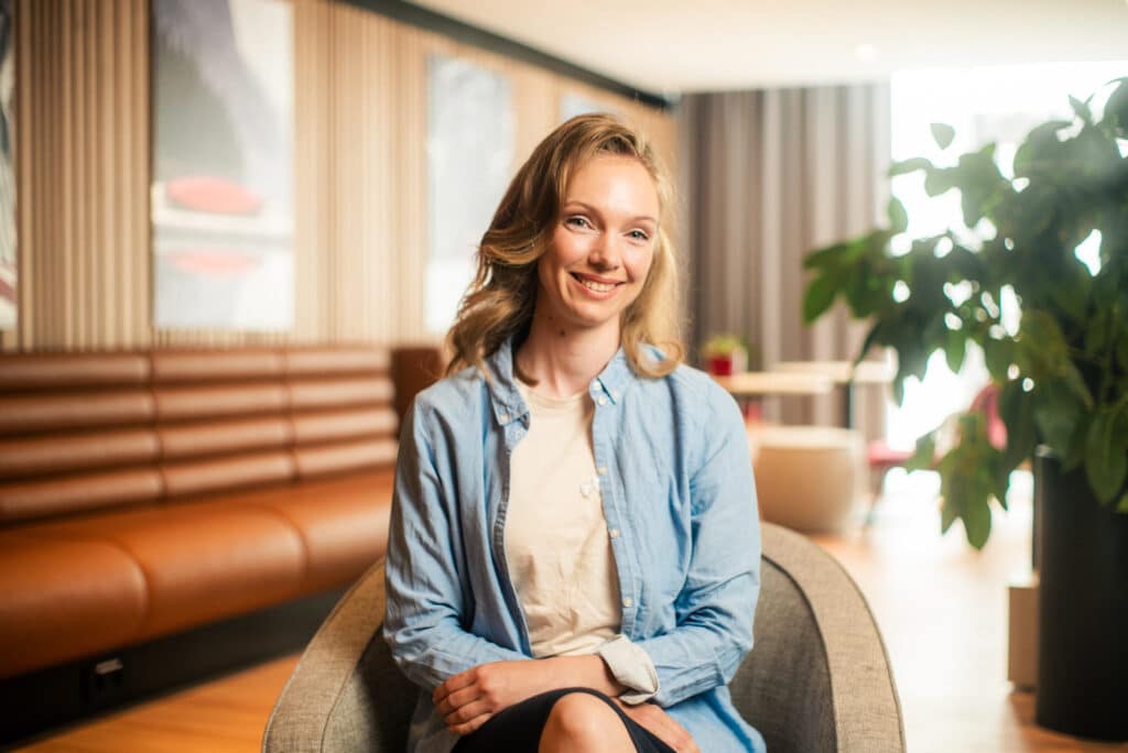 Bilde av Mari som sitter på en stol og smiler