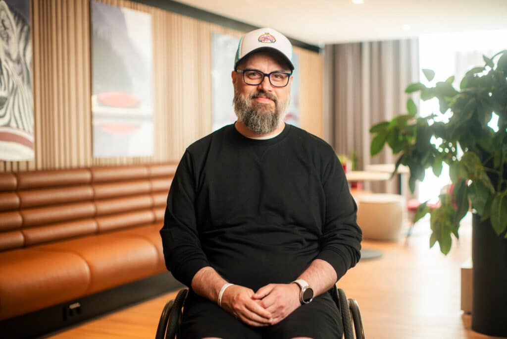 Roy Tore som lever med MS sitter i rullestol med fin bakrunn